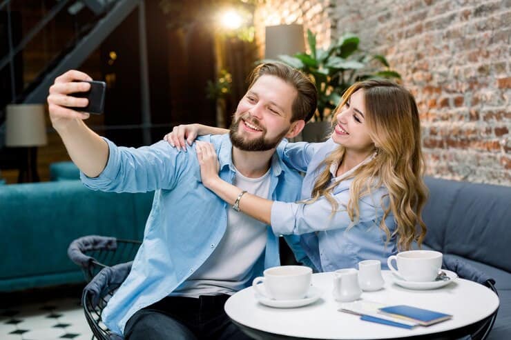 Romantic Things To Do In Indianapolis For Couples : Couple having a selfie at a coffee table - Credits: Freepik
